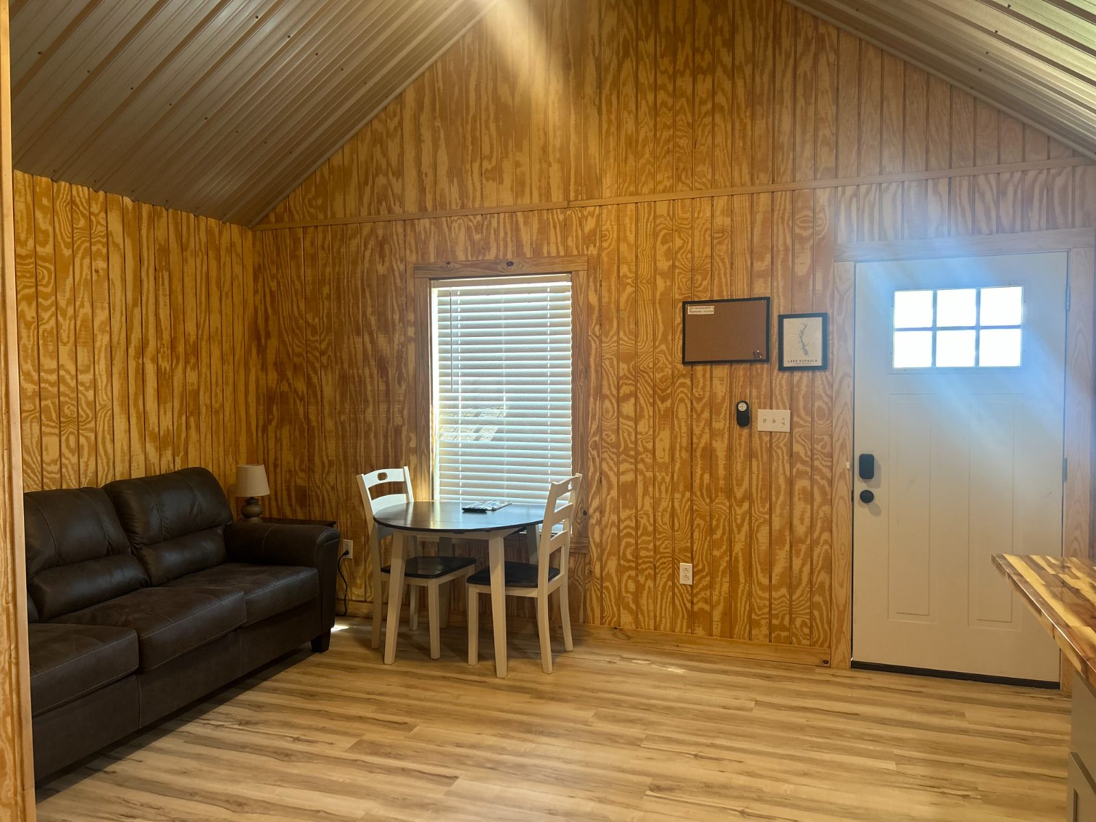 Sofa, dining table and front door inside a cabin